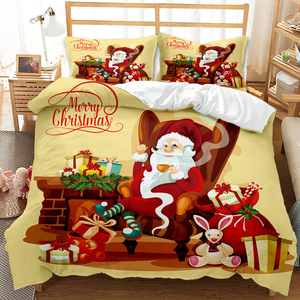 Festive bedding set featuring Santa Claus enjoying tea by a fireplace, surrounded by gifts and a Christmas wreath. "Merry Christmas" text is displayed on pillows and comforter.