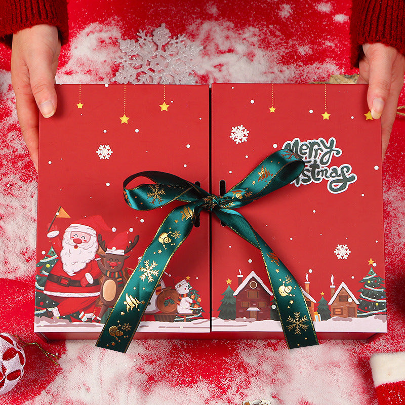 Hands holding a red Christmas gift box with festive snowman and Santa illustrations, decorated with a green ribbon, on a snowy red background.