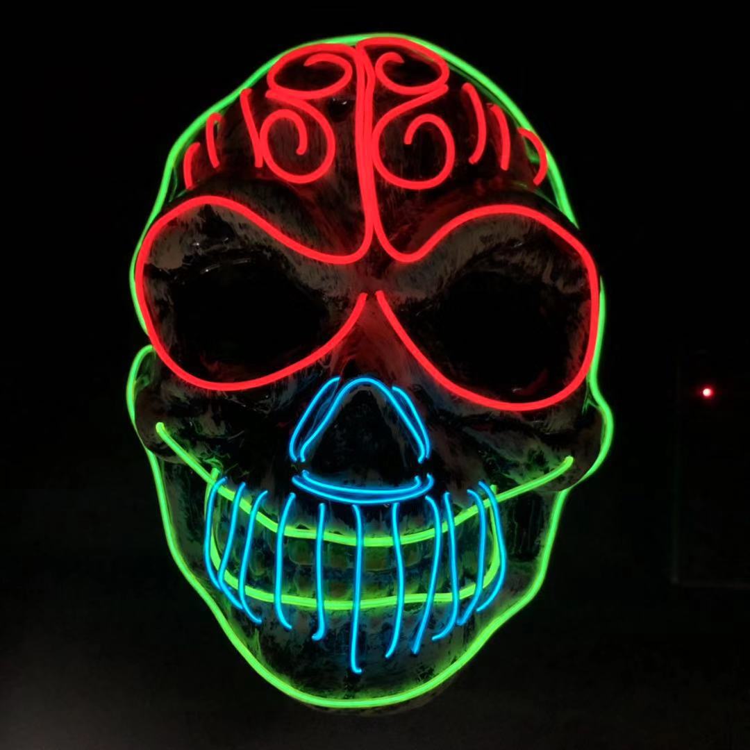 Neon skull art with vibrant colors: red outlines the eyes and forehead, green shapes the face, and blue highlights the nose and mouth, against a dark background.