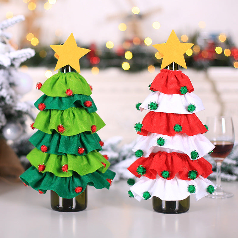 Two wine bottles dressed as Christmas trees, adorned with ruffled green and red-white fabric, topped with stars, decorated with red and green pom-poms, set against a festive background.