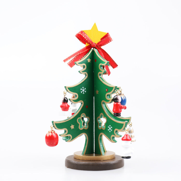 Miniature green Christmas tree with star and red bow on top, adorned with small festive ornaments, stands on a round base.