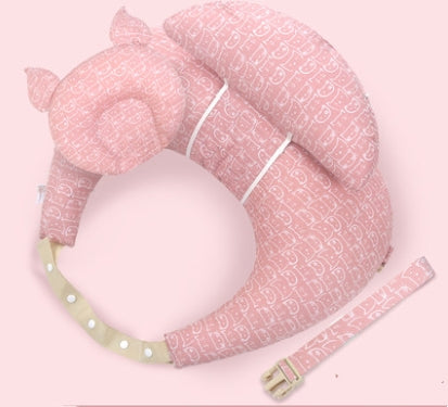 A soft, pink neck pillow with cat ear designs, featuring a subtle cat pattern. It has two straps: a white belt-like strap and a detachable pink strap with a green buckle and white dots.