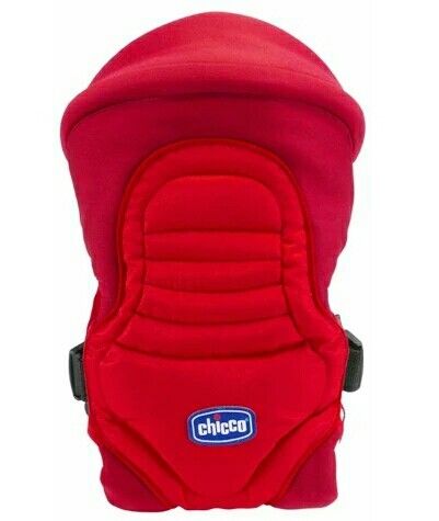 Red baby carrier with padded straps and ergonomic design. Features a central pocket with a blue and white logo patch. Side buckles for secure fastening, suitable for infants.
