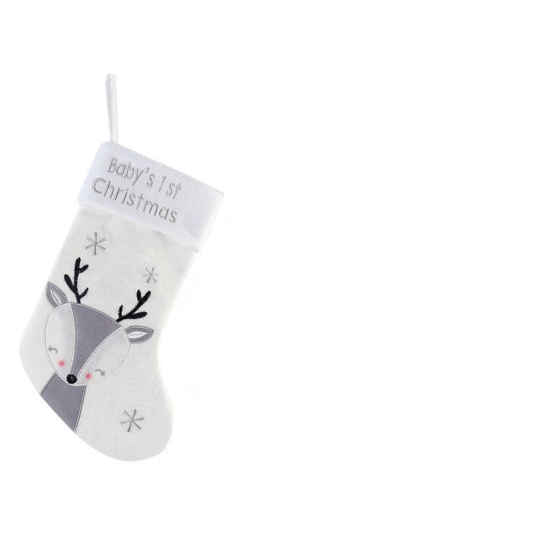 White Christmas stocking with "Baby’s 1st Christmas" embroidered, featuring a cute reindeer design and snowflakes. The stocking is hanging on a white background.