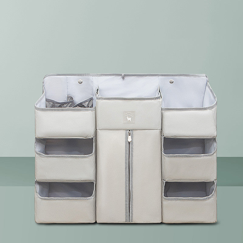Gray multi-pocket hanging organizer with a zippered central compartment and six side pockets, designed for efficient storage and organization against a light green background.