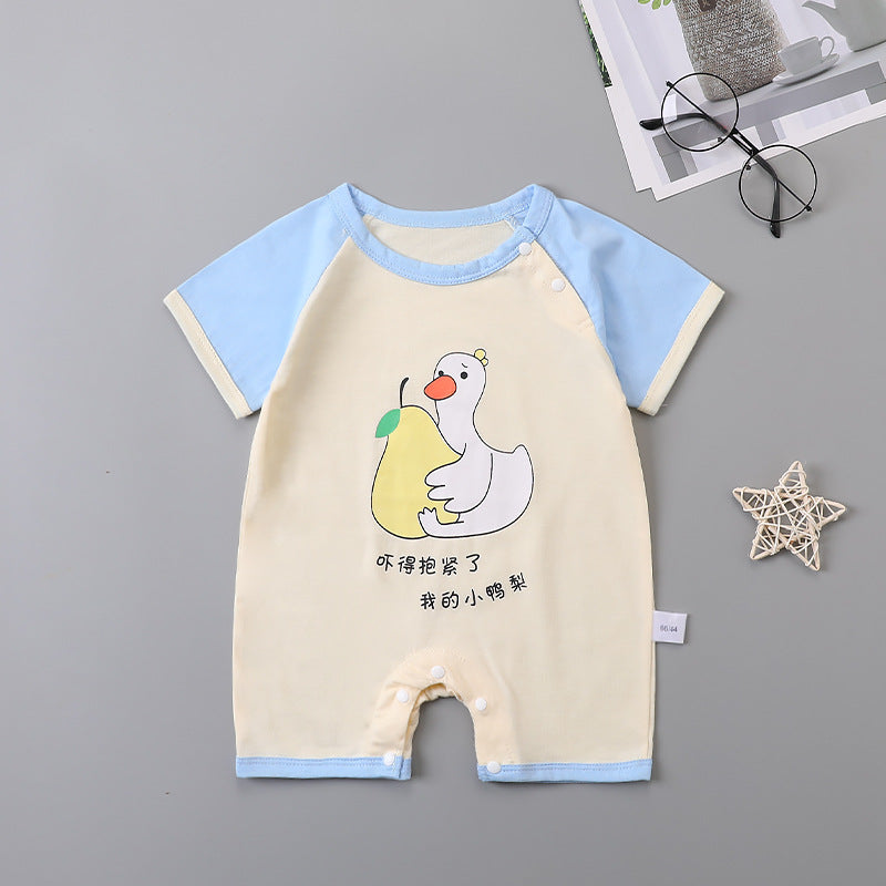 Baby romper with light blue sleeves features a cartoon duck holding a yellow pear. Chinese characters are printed below. Nearby are round glasses, a patterned star, and a magazine.