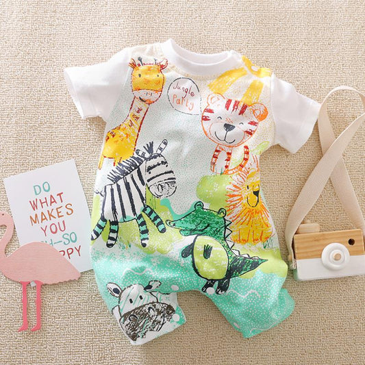 Colorful baby romper with jungle animals like giraffe, tiger, zebra, and crocodile on a beige background. Nearby, a wooden toy camera and a card saying "Do what makes you happy."