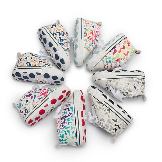 A circle of colorful toddler sneakers with various geometric and polka dot patterns, featuring brand logos on the sides and vibrant soles, arranged in an outward-facing pattern.