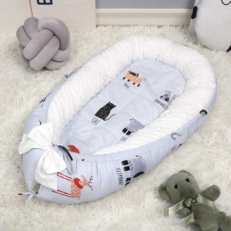 Baby nest with animal print on plush carpet, featuring cartoon animals like a pug and a squirrel. A plush teddy bear and a soft, knot-shaped pillow are nearby.