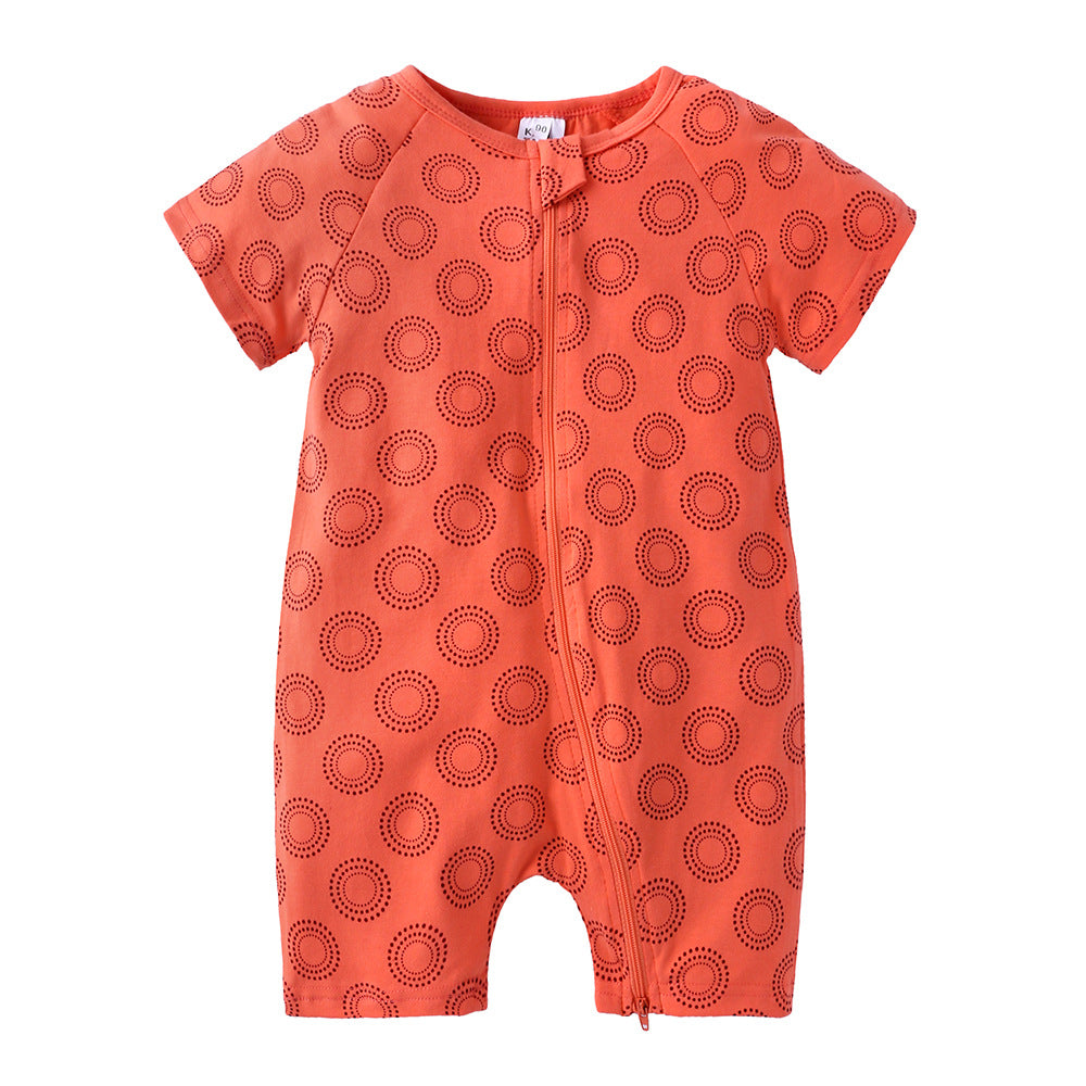 Orange baby romper with short sleeves, featuring a pattern of small, circular dots arranged in concentric circles. It has a zipper and tab closure down the front.