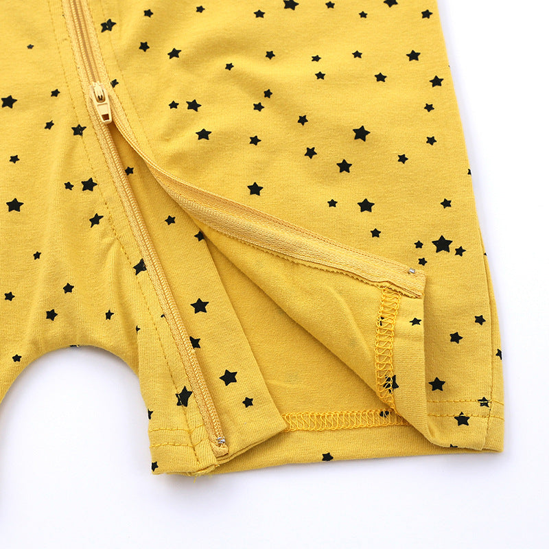Close-up of a yellow fabric with a pattern of small black stars, featuring a zipper and overlapping seam detail.