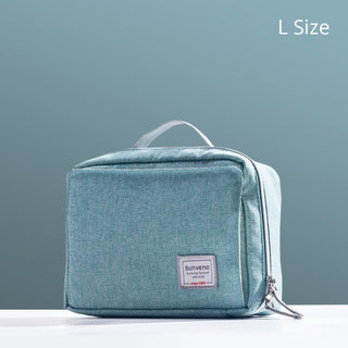 Light blue toiletry bag labeled "L Size" with a top handle and zipper. It features a small front patch, positioned on a white surface against a blue-gray background.