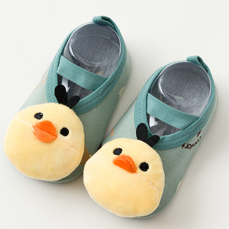 Green baby shoes with elastic straps, featuring plush yellow chick faces with orange beaks and black eyes on the toes.