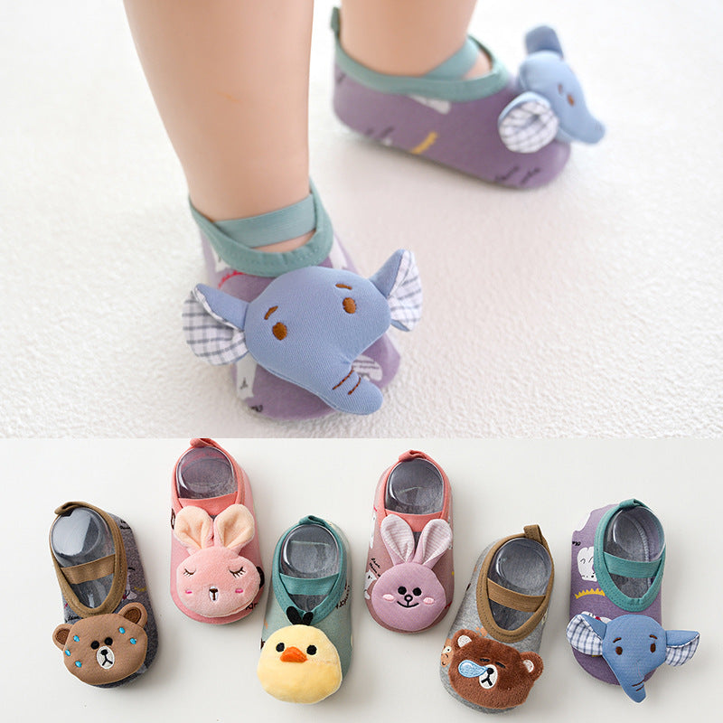 Baby wearing purple animal-themed shoes with blue elephant faces. Below, five pairs of toddler shoes with various animal designs: bear, bunny, chick, and another bear.