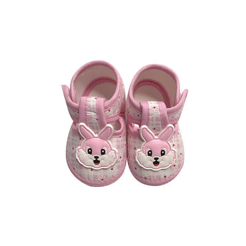 Pink baby shoes with playful bunny faces on the front. The shoes have patterned fabric and secure straps, designed for comfort and style.