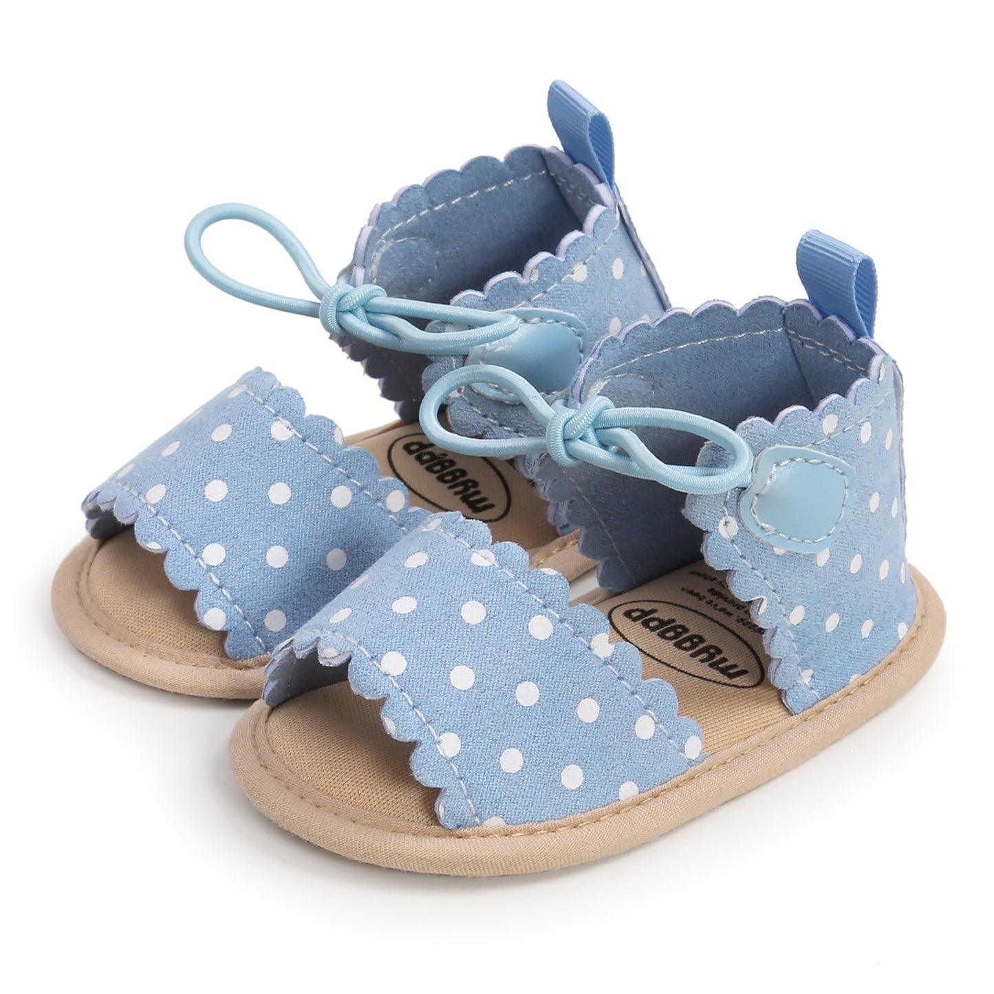 Blue baby sandals with white polka dots and scalloped edges, featuring light blue laces and a soft beige sole.