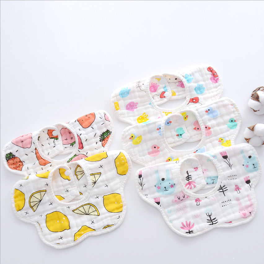 Five colorful baby bibs with cute patterns, including fruits, ducks, and bunnies, arranged neatly on a white background.