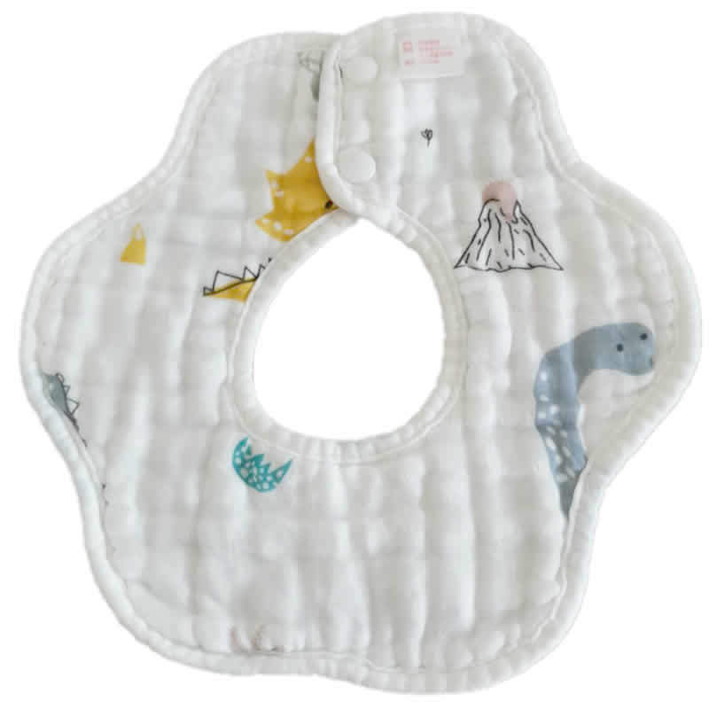 White baby bib with cute dinosaur and volcano prints, featuring a round central opening and textured fabric. Two snap buttons are visible for fastening.