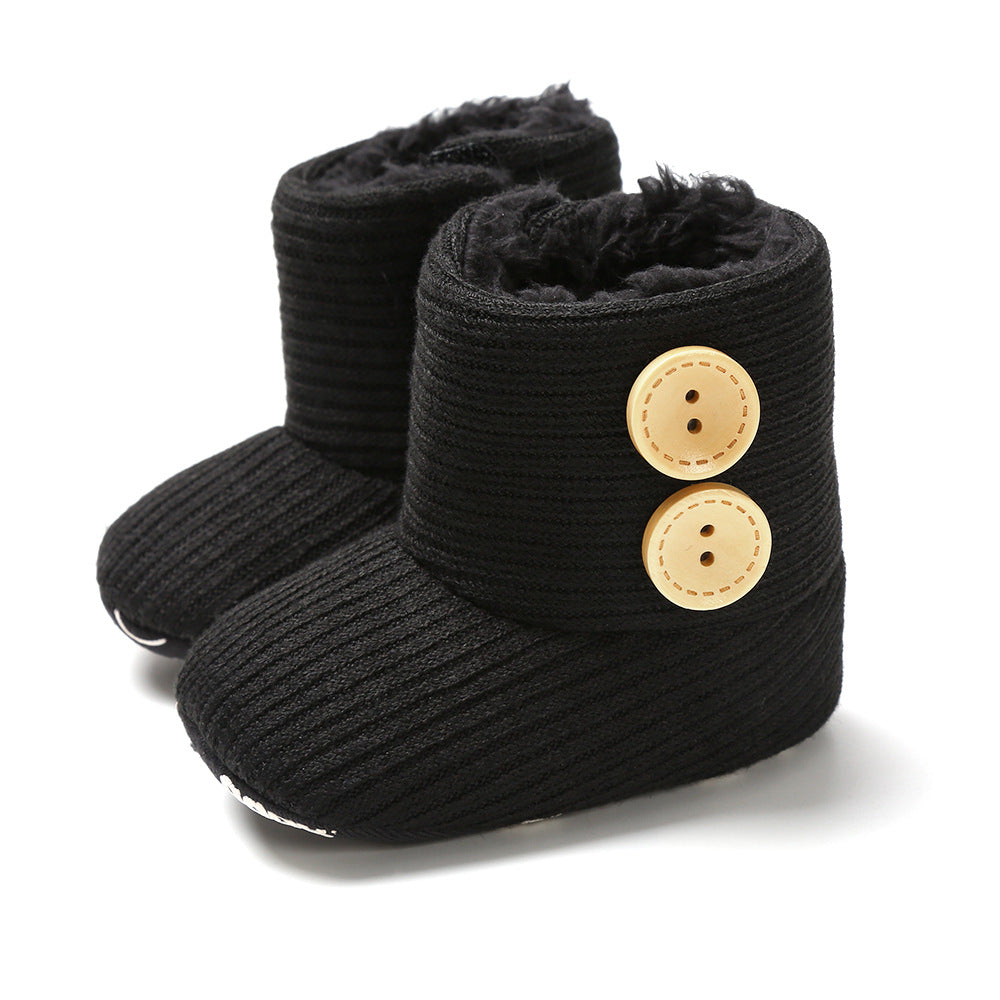 Black knitted baby boots with two wooden buttons on each side and a soft, fluffy interior.