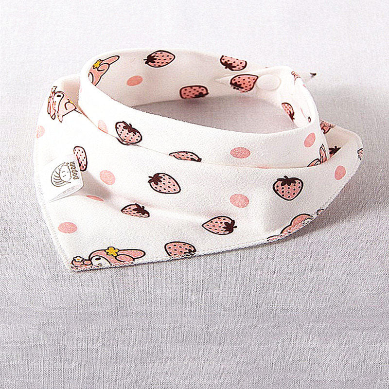 White baby bib with pink strawberries and polka dots, featuring cute characters. It has a soft texture and a small tag, displayed on a light gray surface.