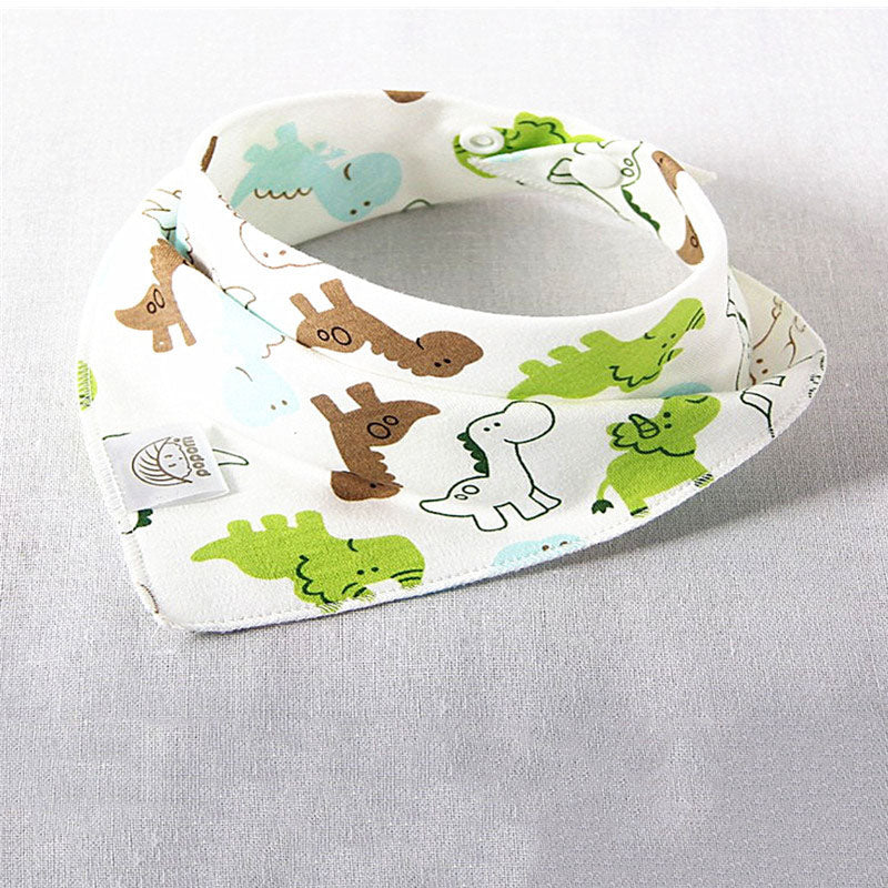 White baby bib with colorful dinosaur prints in green, brown, and blue, laid flat on a light gray surface. Features a snap closure and a small logo tag.