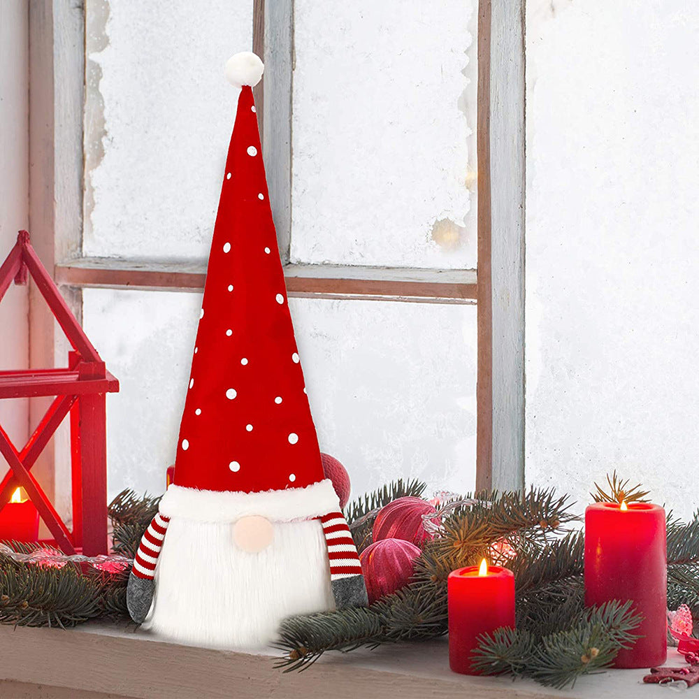 Festive gnome with a red polka dot hat sits on a windowsill, surrounded by pine branches and lit red candles. The background shows frosted windowpanes and a red lantern.