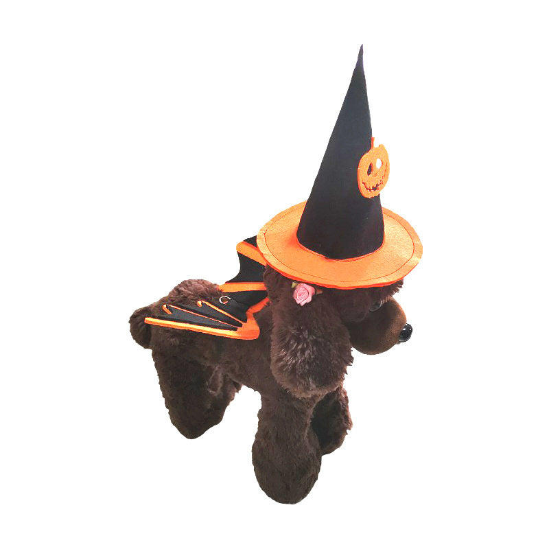 A brown stuffed dog wearing a black witch hat with an orange band and pumpkin, and matching orange and black bat wings, ready for Halloween.