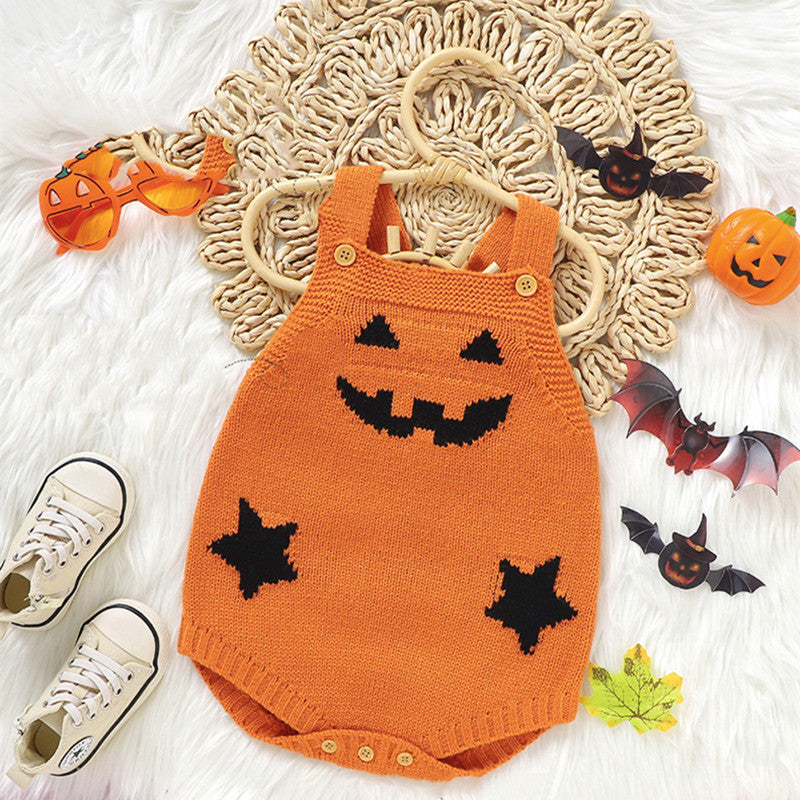Orange knit baby romper with a jack-o'-lantern face and star patches, surrounded by Halloween decorations, sneakers, and pumpkin-shaped sunglasses on a white, textured background.