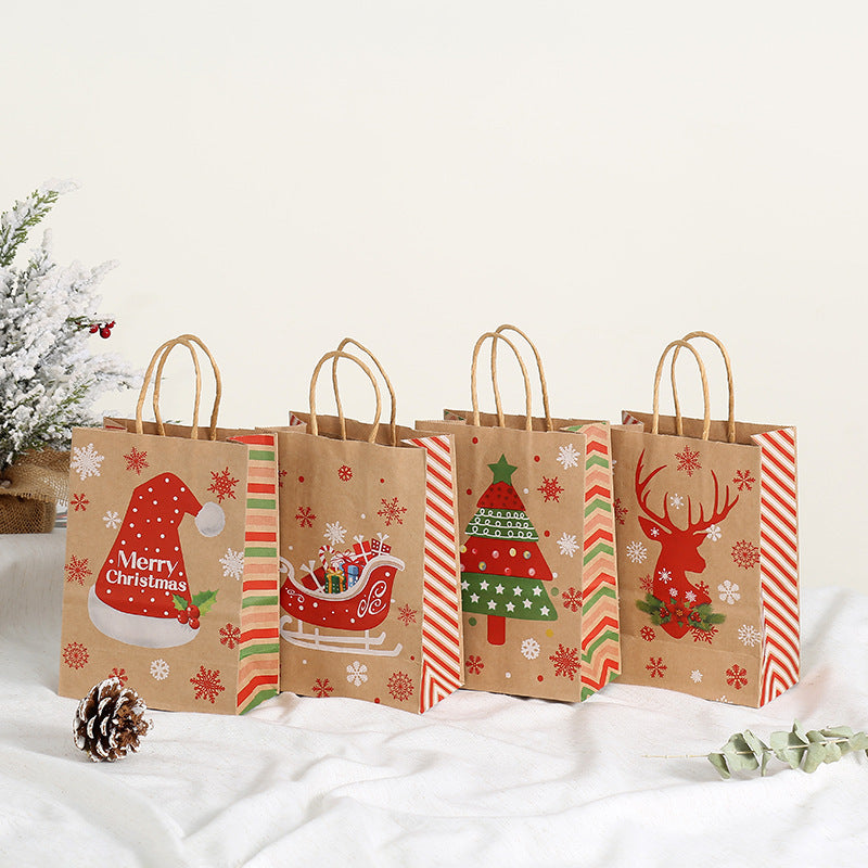Four brown paper gift bags with festive Christmas designs: Santa hat, sleigh, Christmas tree, and reindeer. Each bag has red and green striped sides. Snowy decor nearby.