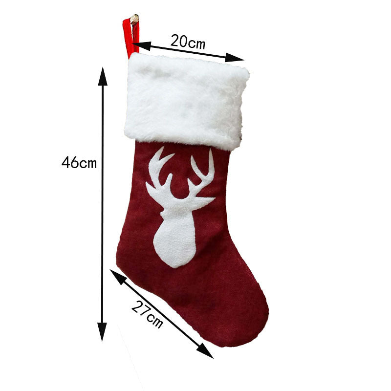 Red Christmas stocking with a white fur cuff, featuring a white deer silhouette. It measures 46 cm tall, 27 cm wide, and 20 cm across the top with a red hanging loop.