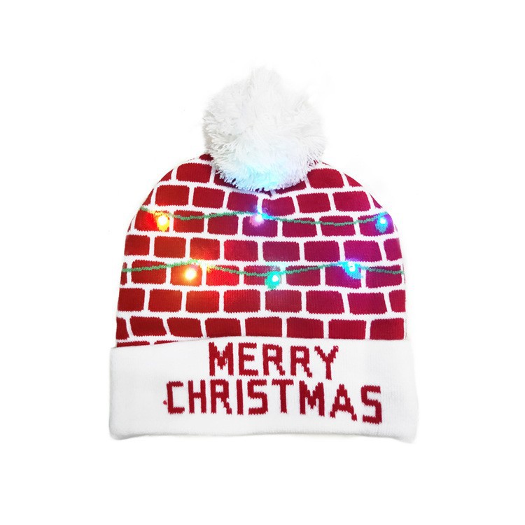 Red and white beanie with a brick pattern, adorned with colorful lights and a fluffy pom-pom top. The brim reads "Merry Christmas" in bold red letters.