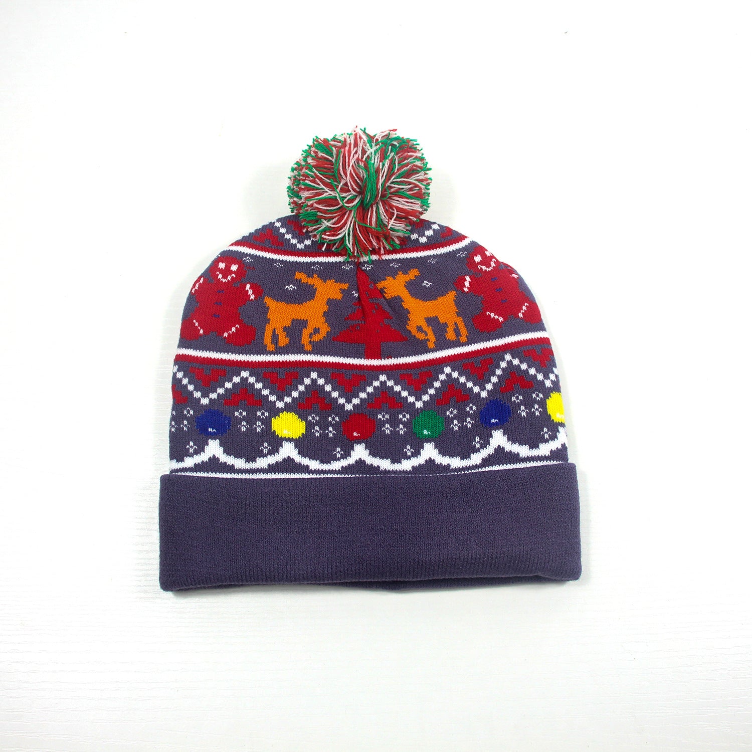 Knitted winter hat with red, green, and white pom-pom. Features festive designs of gingerbread men, reindeer, and snowflakes on a navy and red background.
