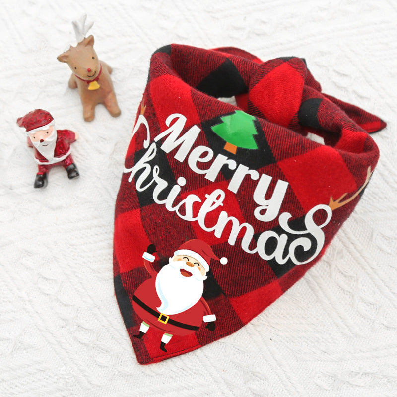 Red and black plaid bandana with "Merry Christmas" text and Santa design on a white background, alongside small Santa and reindeer figurines.