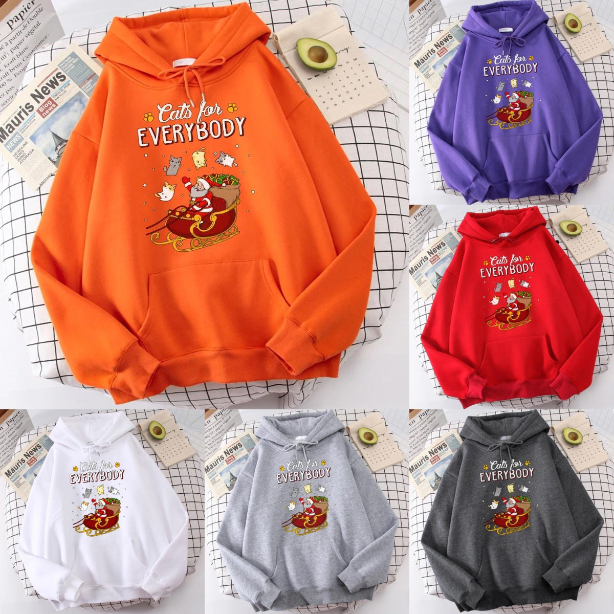 Colorful hoodies with "Cats for Everybody" print and a Santa cat on a sleigh design. Displayed in orange, purple, red, white, gray, and dark gray on a grid-patterned surface.