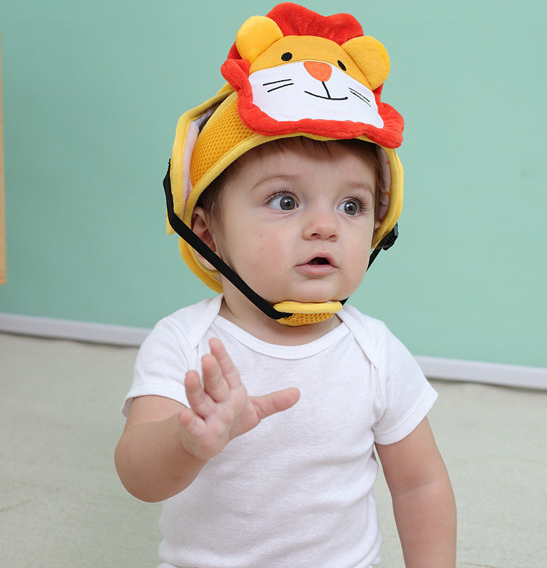 A baby wearing a cute lion-themed helmet and a white shirt raises one hand slightly. The background is teal, adding a playful atmosphere.