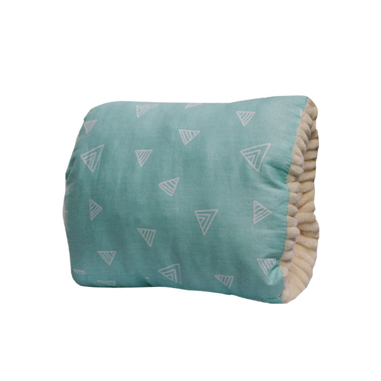 Soft teal pillow with a pattern of white triangles, featuring a plush beige interior lining visible at the edge, designed for comfort and style.