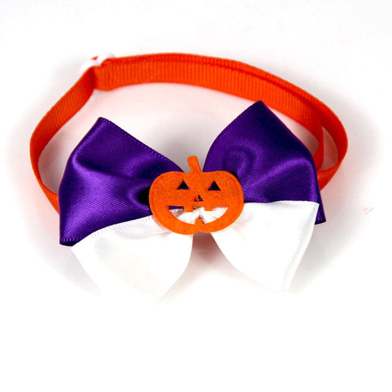 Halloween-themed bow tie with purple and white satin ribbons, featuring an orange jack-o'-lantern in the center, attached to an orange elastic band.
