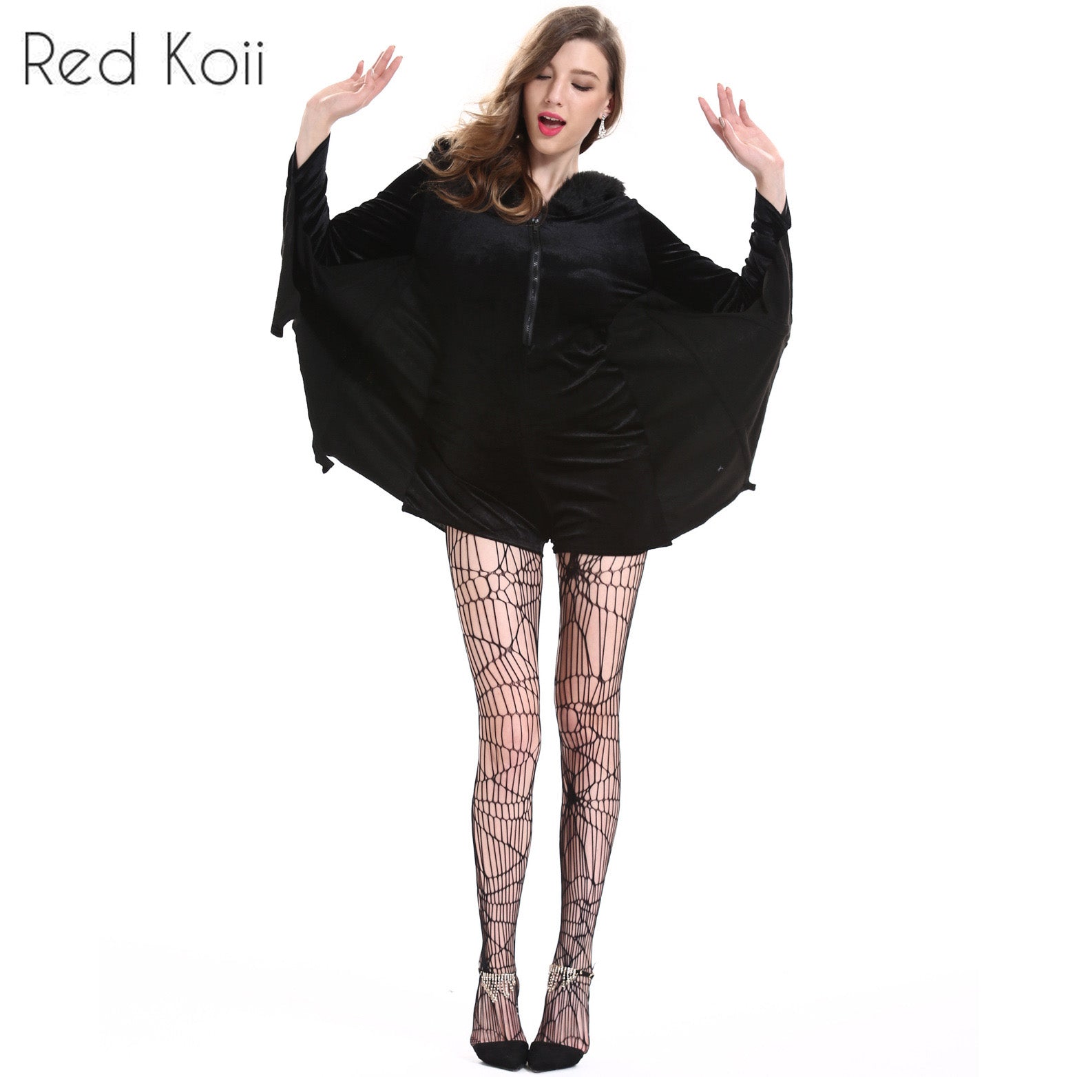 Woman dressed as a bat in a black velvet costume with wing-like sleeves and web-patterned tights. Her arms are raised, and she's wearing pointed black shoes.