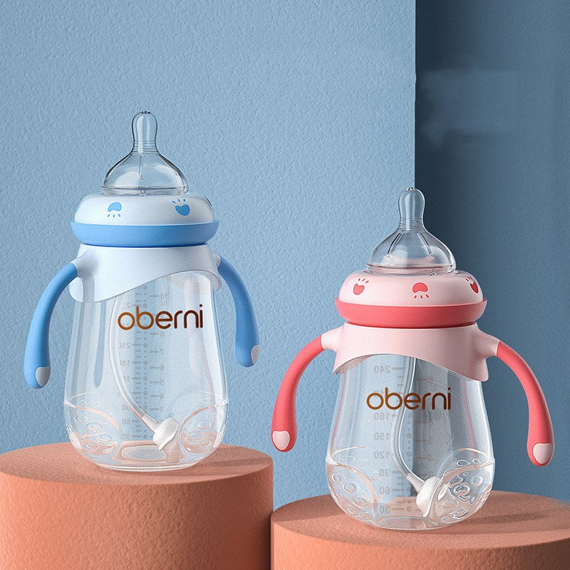 Two baby bottles with handles and straws, one blue and one pink, are displayed on orange platforms against a light blue background. Both feature playful designs and clear measurements.
