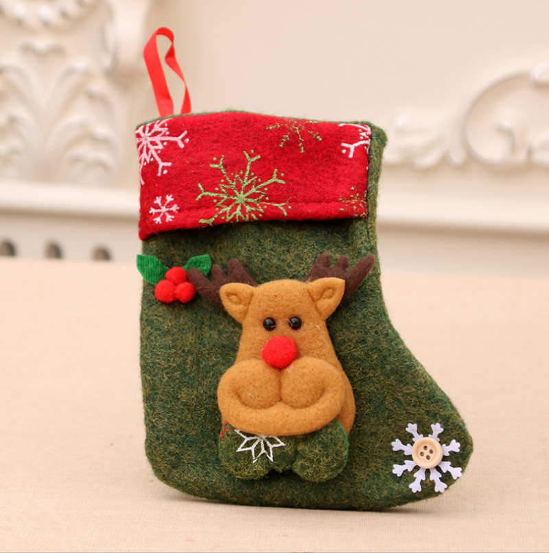 A green Christmas stocking with a red top, adorned with white snowflakes. It features a cute reindeer face with a red nose and ears, and a small snowflake button.