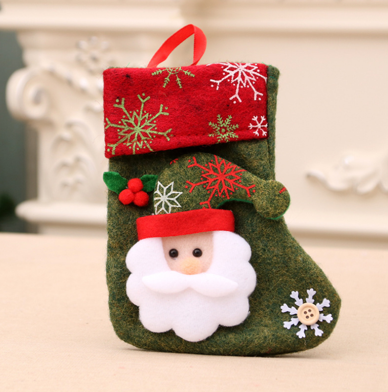 Festive Christmas stocking featuring a felt Santa Claus with a white beard on green fabric. Red cuff with snowflake patterns and a red loop for hanging.