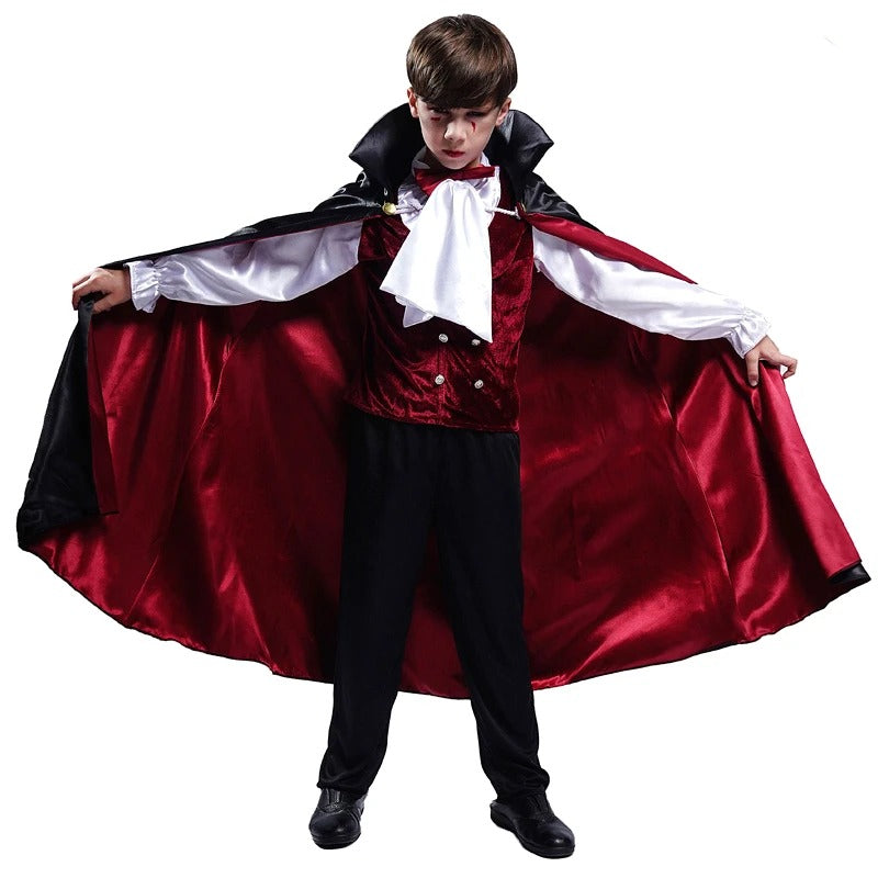 Child dressed as a vampire spreads a red-lined cape, wearing a velvet vest, white shirt, and bow tie, embodying a classic Halloween costume with dramatic flair.
