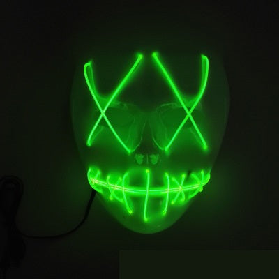 A glowing green LED mask features stitched mouth lines and X-shaped eyes, creating an eerie expression against a dark background.