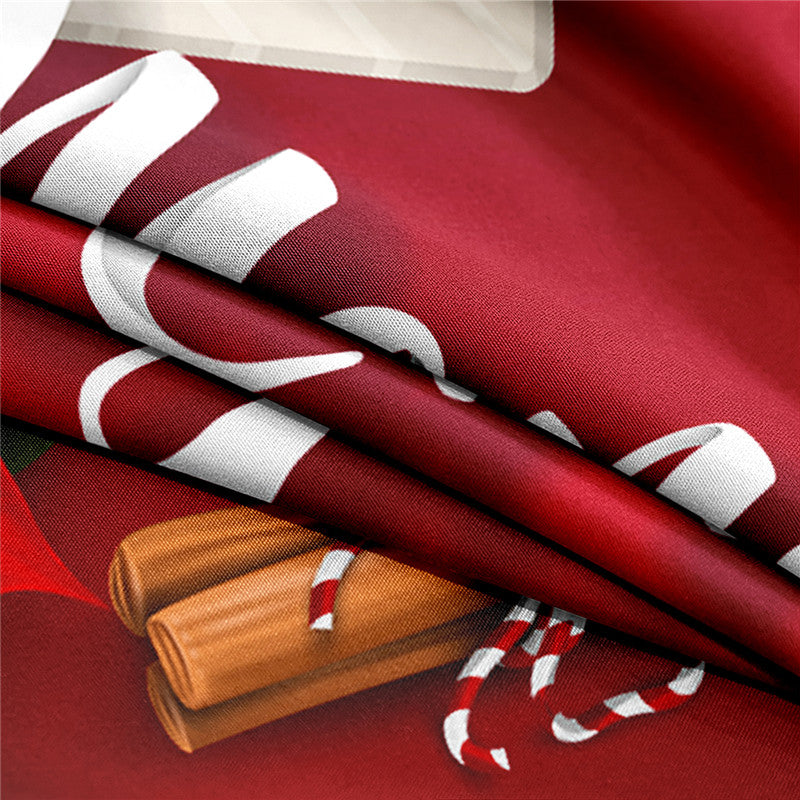 Close-up of folded red fabric with partial white text and a print of cinnamon sticks and candy canes. The fabric displays a festive, holiday-themed design.