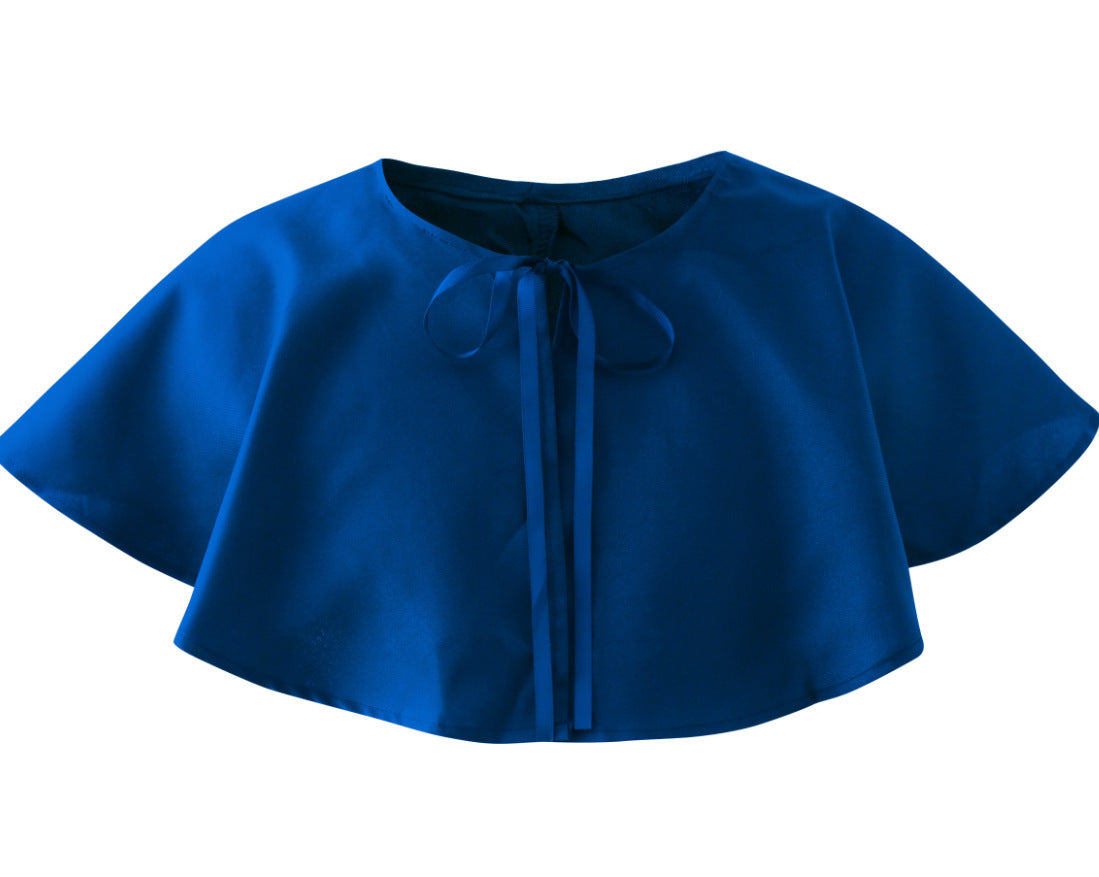 A royal blue short cape with a round neckline and front tie closure, featuring wide sleeves and a smooth fabric finish.