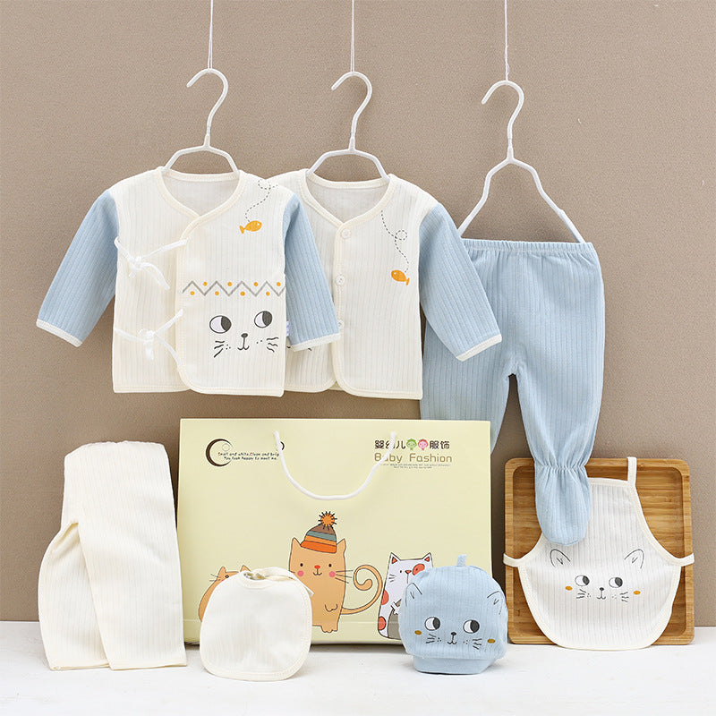 Adorable baby clothing set with pastel blue and cream tones, featuring cat designs. Includes two tops, pants, a bib, a hat, and a gift bag with cat illustrations.