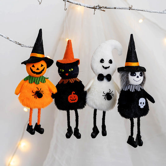 Four Halloween plush ornaments hang from a branch: a smiling pumpkin, a witchy black cat, a cheerful ghost, and a gothic skeleton, all wearing whimsical hats.