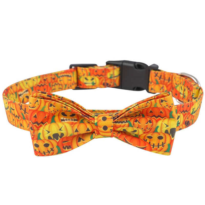 Orange dog collar with a bow tie featuring smiling jack-o'-lantern designs. The collar has an adjustable buckle for sizing. Festive and perfect for Halloween.