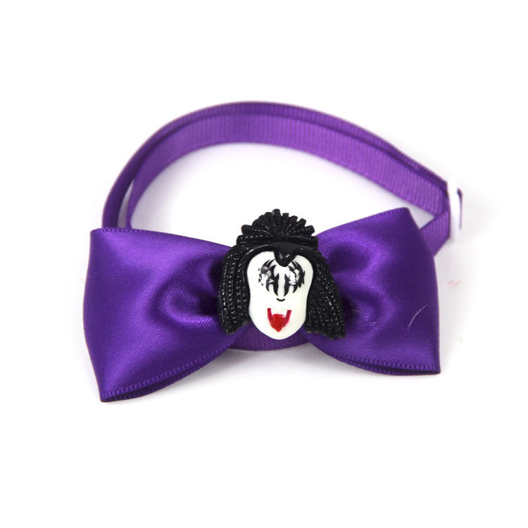 Purple satin bow tie with a decorative face emblem featuring black hair, white face, and red lips. The band is adjustable with a simple clasp.