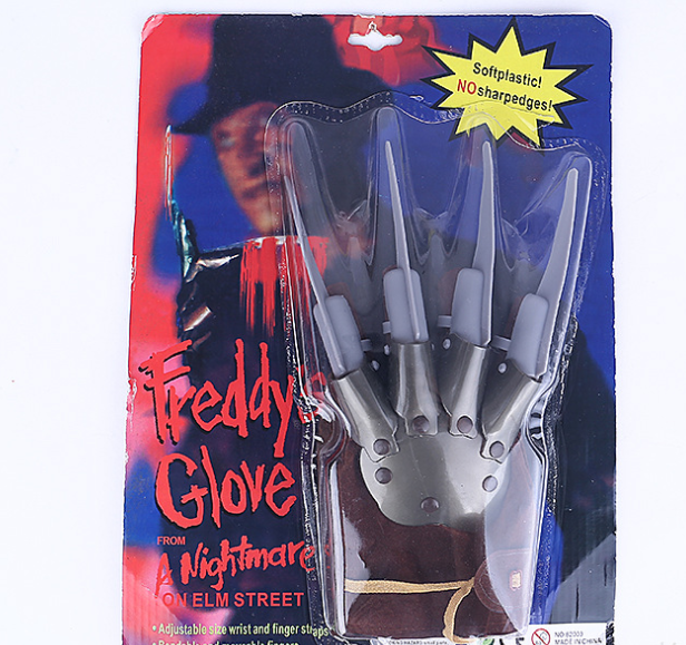 Toy Freddy Krueger glove packaged on a card with "Freddy's Glove from A Nightmare on Elm Street" text. Soft plastic, no sharp edges. Features adjustable wrist and finger straps.